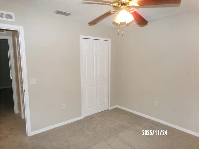 an empty room with a window and a fan