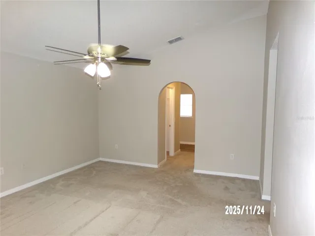 an empty room with chandelier fan
