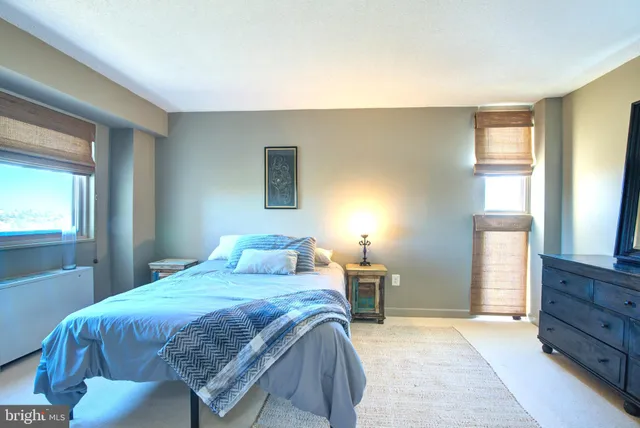 a bedroom with a bed and a dresser next to a window