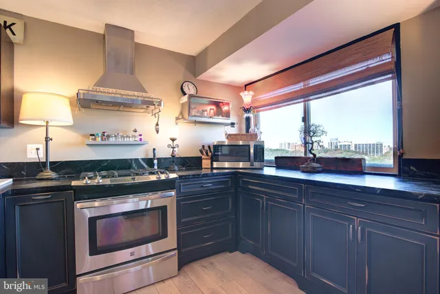 a kitchen with a stove a sink and a window