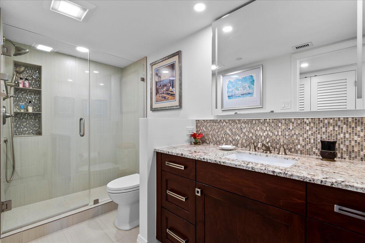 3322 Casseekey Island Road, Unit 901 Jupiter, FL 33477 - Photo 28 of 68 a bathroom with a granite countertop sink a toilet and a shower