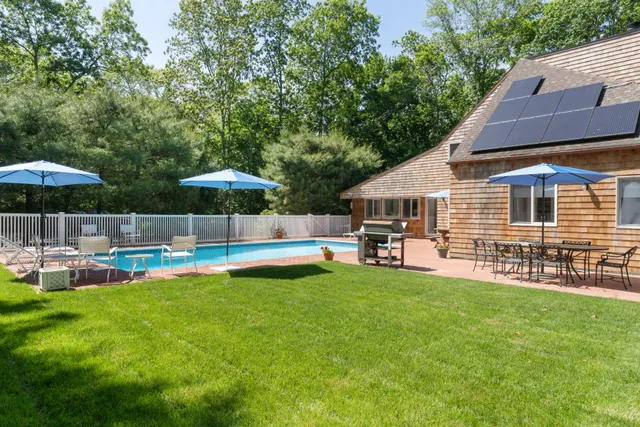 a view of a house with a yard patio and swimming pool
