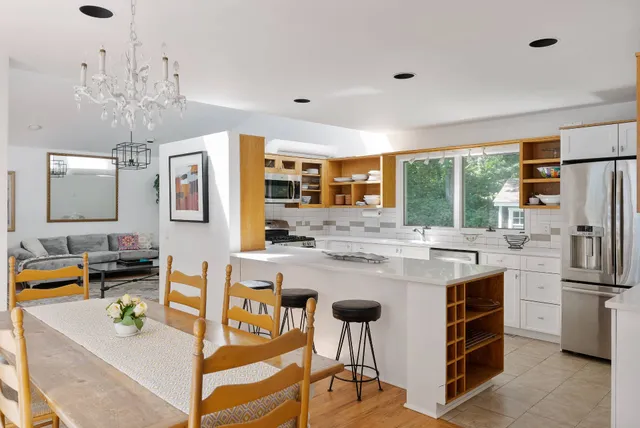 a kitchen with kitchen island granite countertop a sink appliances and cabinets
