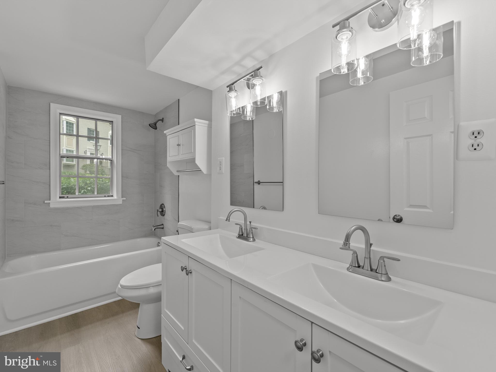 708 South Arlington Mill Drive, Unit 104 Arlington, VA 22204 - Photo 14 of 24 a bathroom with a sink double vanity granite tub and a mirror