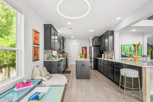 a kitchen with stainless steel appliances granite countertop a refrigerator a stove top oven a sink and dishwasher with wooden floor