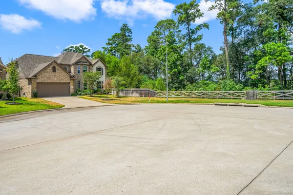 a view of a house with a yard and a large tree