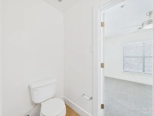 a white toilet sitting next to a shower