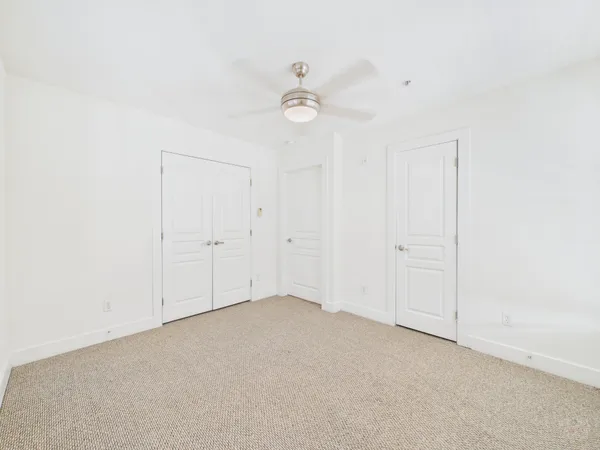 an empty room with a ceiling fan and a window