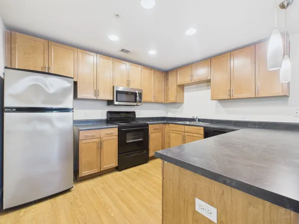 a kitchen with granite countertop a refrigerator sink and microwave