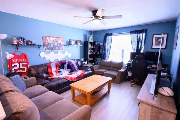 a living room with furniture a ceiling fan and a window