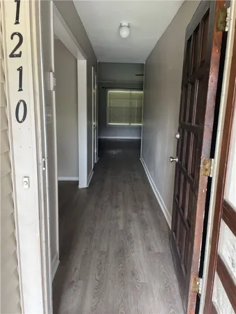 a view of a hallway with wooden floor and staircase