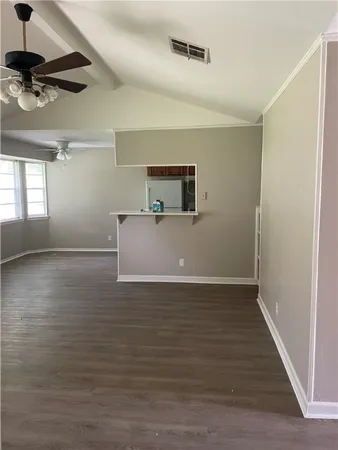 a view of empty room with wooden floor