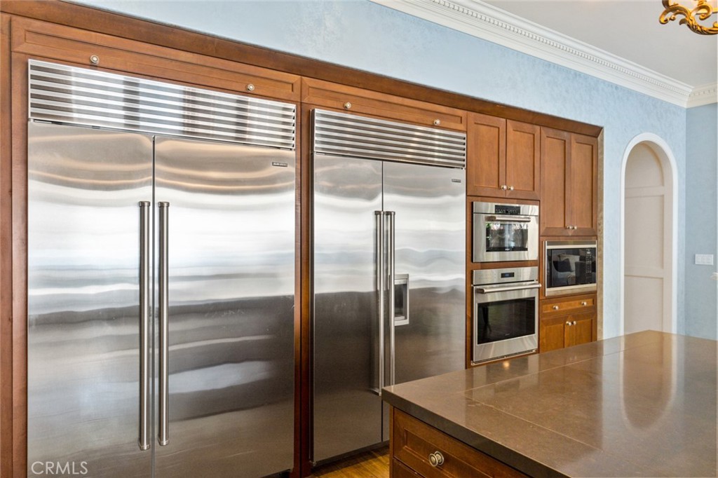 121 Treasure Irvine, CA 92602 - Photo 16 of 41 a kitchen with stainless steel appliances granite countertop a refrigerator a stove and a sink with wooden floor