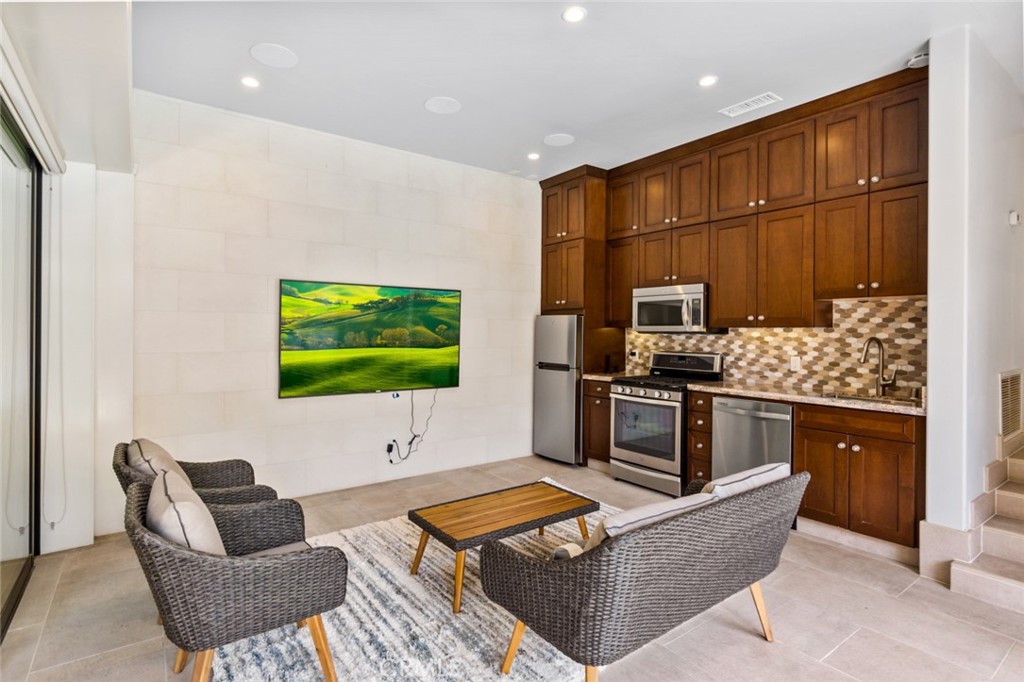 121 Treasure Irvine, CA 92602 - Photo 34 of 41 a living room with furniture a flat screen tv and kitchen view