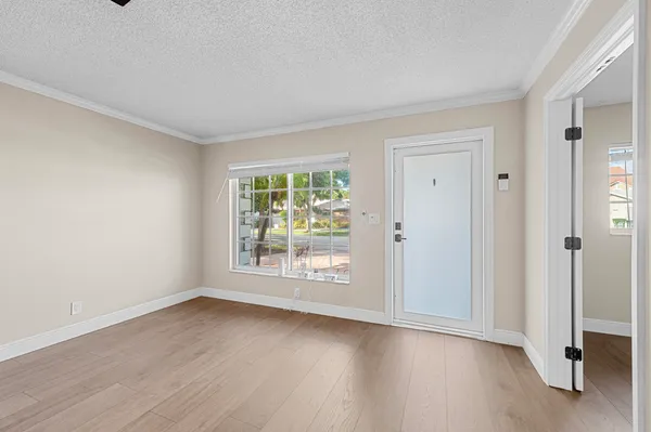 an empty room with wooden floor and ceiling fan