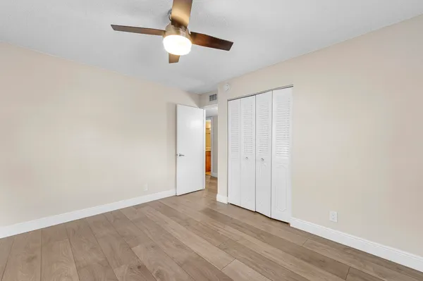 a view of a bedroom with a bed and wooden floor