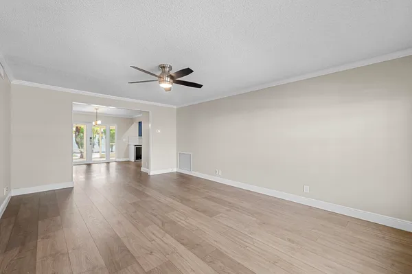 a view of an empty room with wooden floor