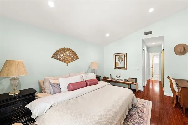 a bedroom with a bed and wooden floor