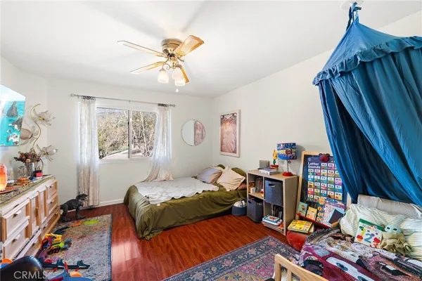 a bedroom with a bed and a wooden floor