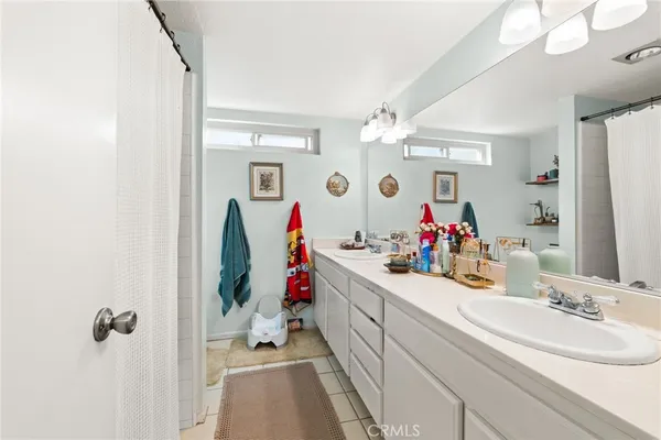 a bathroom with a double vanity sink mirror and shower