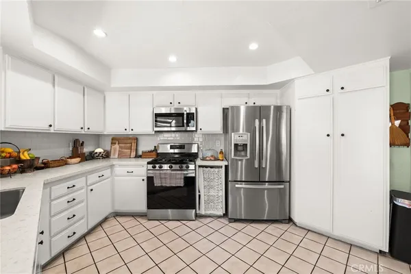 a kitchen with white cabinets stainless steel appliances and sink