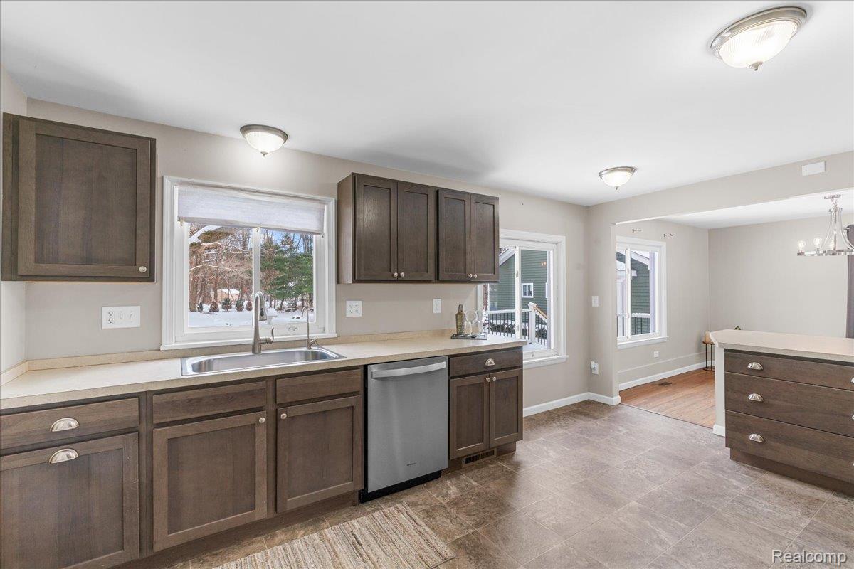 4666 Brighton Road Brighton, MI 48116 - Photo 25 of 37 Kitchen with dark brown cabinets, light countertops, healthy amount of natural light, and dishwasher