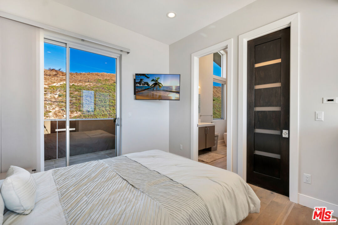 25423 Malibu Road Malibu, CA 90265 - Photo 22 of 71 a bedroom with a bed and a window
