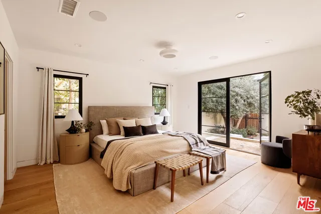 a bedroom with a bed and large windows