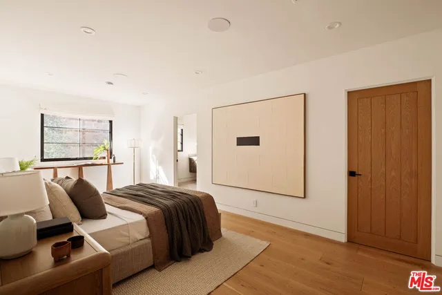 a bedroom with a bed and wooden floor