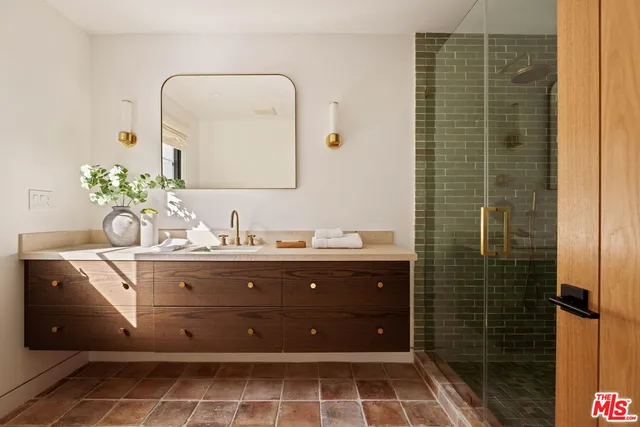 a bathroom with a granite countertop sink a mirror and shower