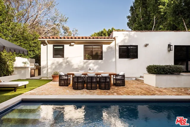 a view of house with swimming pool and sitting area
