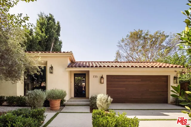 a front view of a house with plants