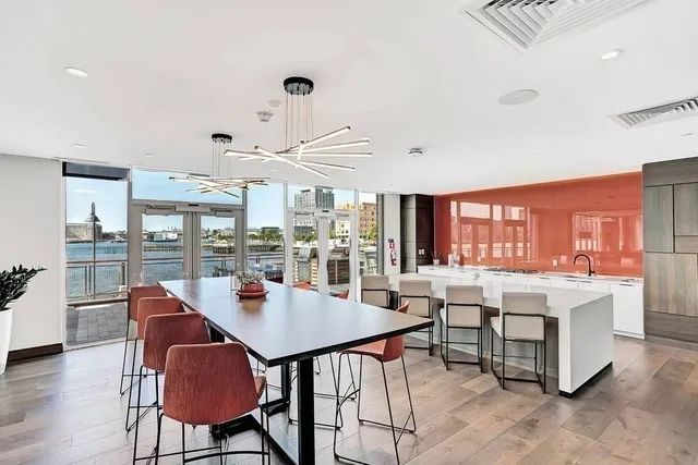 a living room with stainless steel appliances granite countertop a table and chairs in it