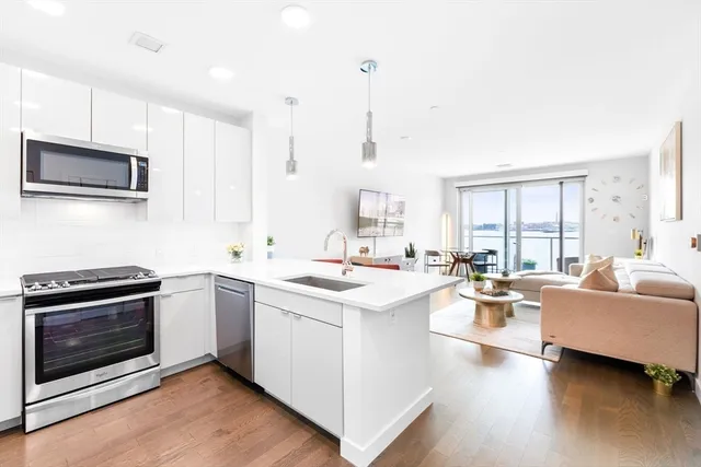 a open kitchen with stainless steel appliances kitchen island granite countertop a stove and a sink with cabinets
