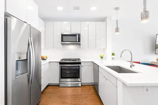 a kitchen with stainless steel appliances a refrigerator sink and microwave
