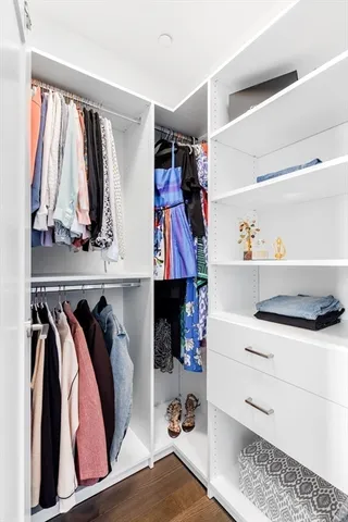 a view of walk in closet with clothes and shoes