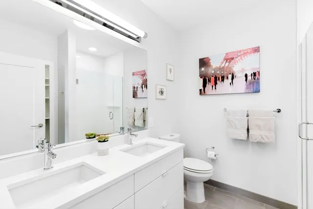 a bathroom with a sink mirror and toilet