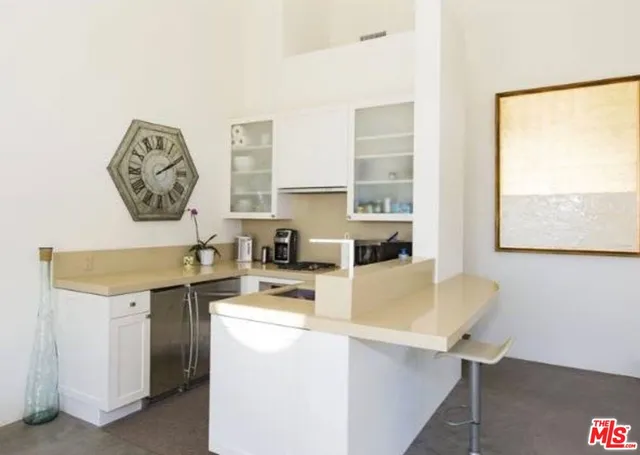 a room with a window a sink and a dining table with chairs