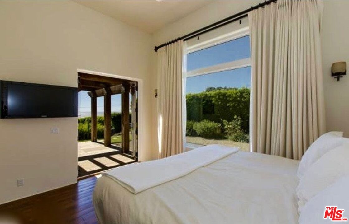 29458 Bluewater Road, Unit GUESTHOUSE Malibu, CA 90265 - Photo 6 of 16 a bedroom with a bed and glass door