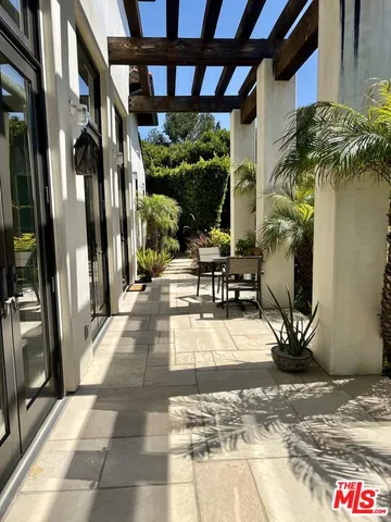 a view of a porch with chairs and potted plants