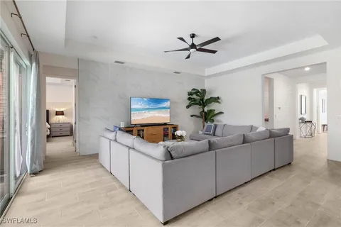a living room with furniture kitchen view and a potted plant