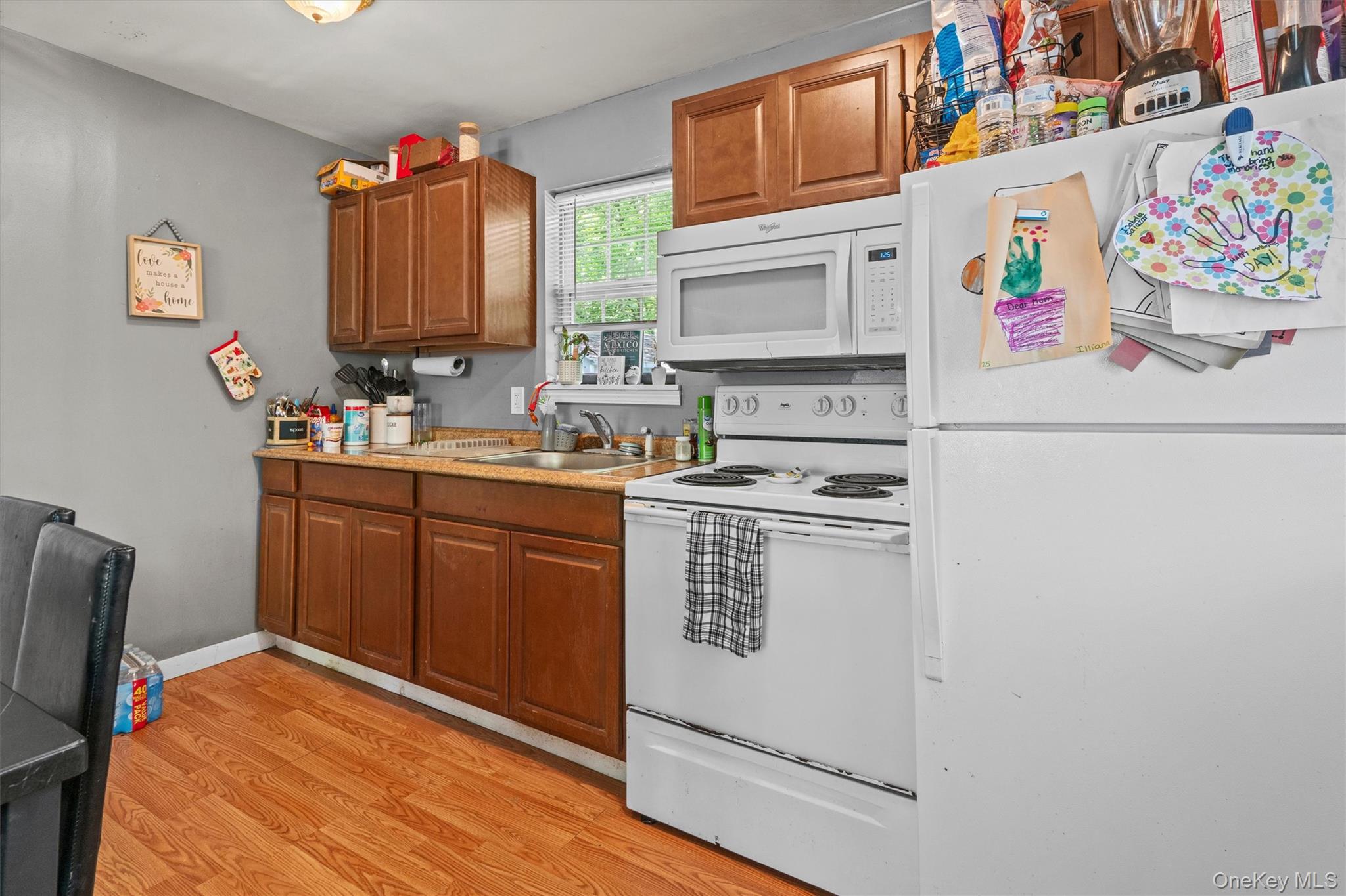359 Lake Shore Drive Pine Bush, NY 12566 - Photo 13 of 25 Kitchen with white appliances, light wood finished floors, brown cabinets, a sink, and light countertops