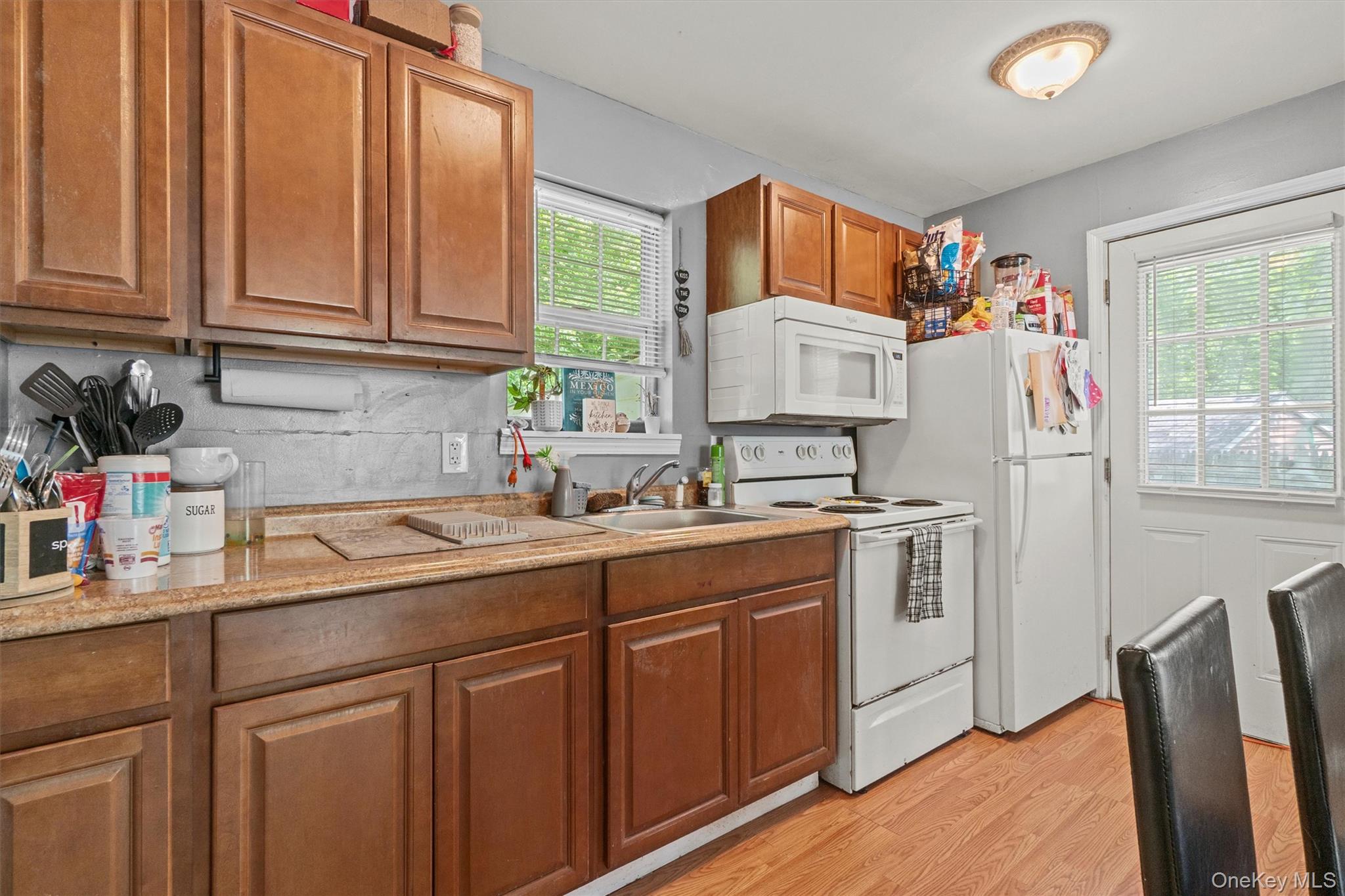 359 Lake Shore Drive Pine Bush, NY 12566 - Photo 14 of 25 Kitchen with white appliances, a sink, light wood-style floors, and brown cabinetry