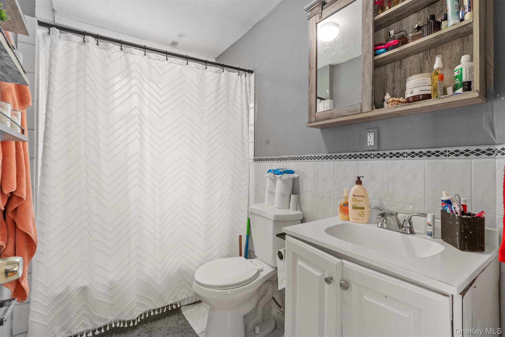 359 Lake Shore Drive Pine Bush, NY 12566 - Photo 17 of 25 Full bathroom with toilet, vanity, tile walls, and curtained shower
