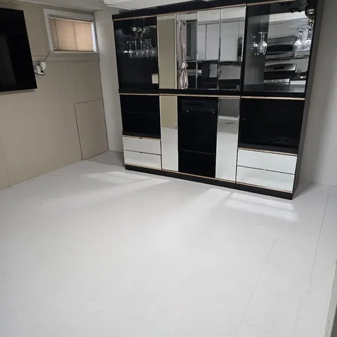 a kitchen with white cabinets and black appliances