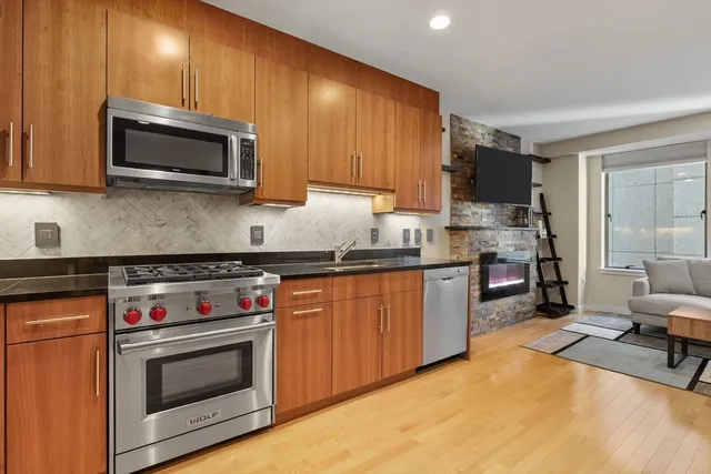 a kitchen with stainless steel appliances a stove a microwave a sink and cabinets