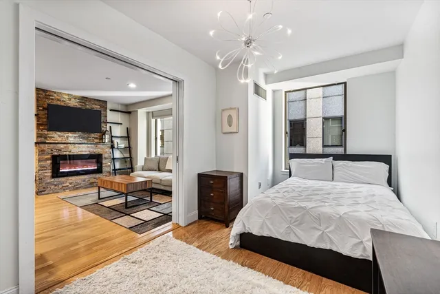 a bedroom with a large bed and a chandelier
