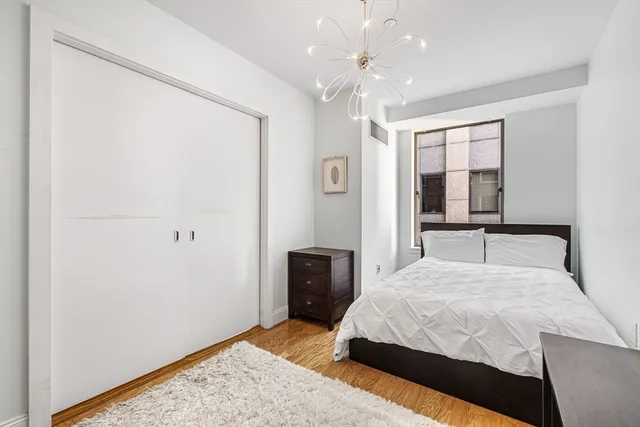 a bedroom with a large bed and a chandelier
