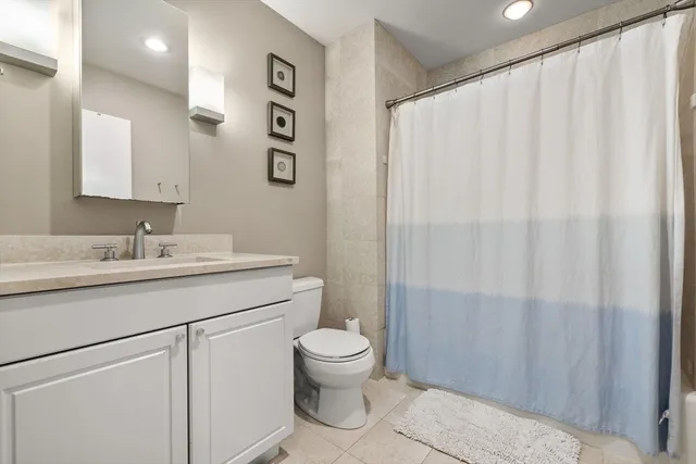 a bathroom with a sink a toilet and shower curtain