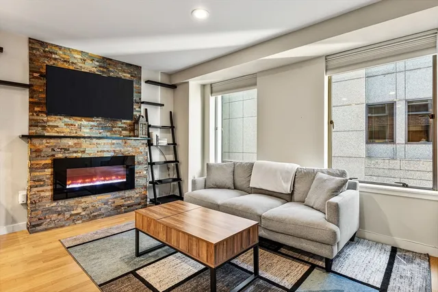 a living room with furniture a flat screen tv and a fireplace